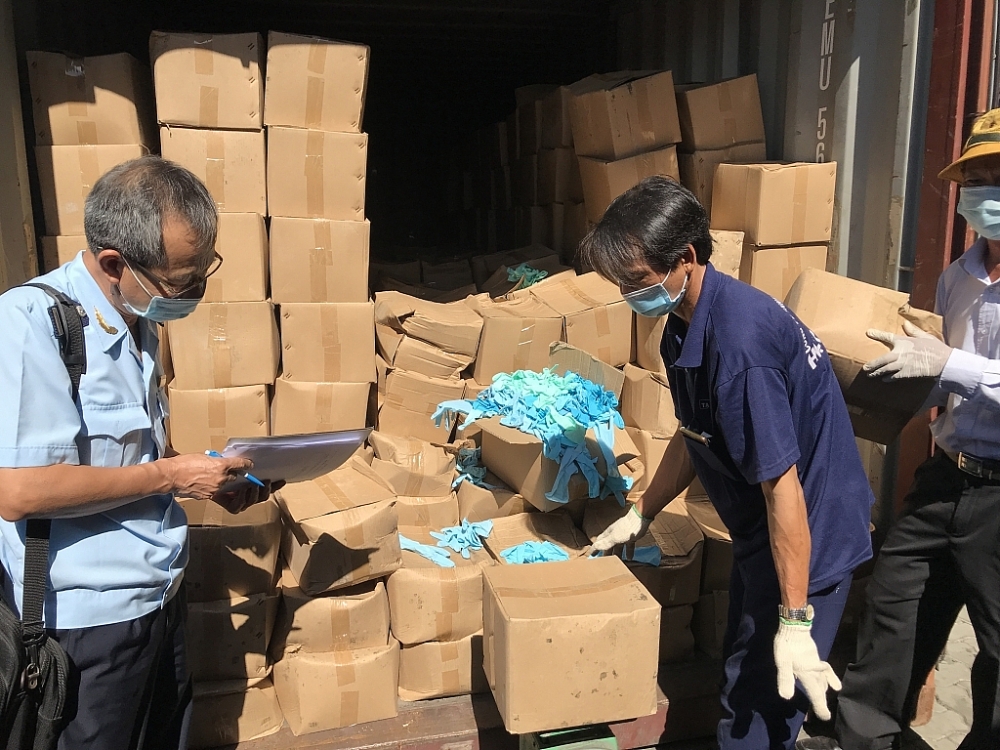 Lô găng tay cao su cũ  của Công ty TNHH Sản xuất và XNK thiết bị y tế Sài Gòn Trading Group nhập khẩu do cơ quan Hải quan bắt giữ tại cảng Cát Lái. 	Ảnh: T.H