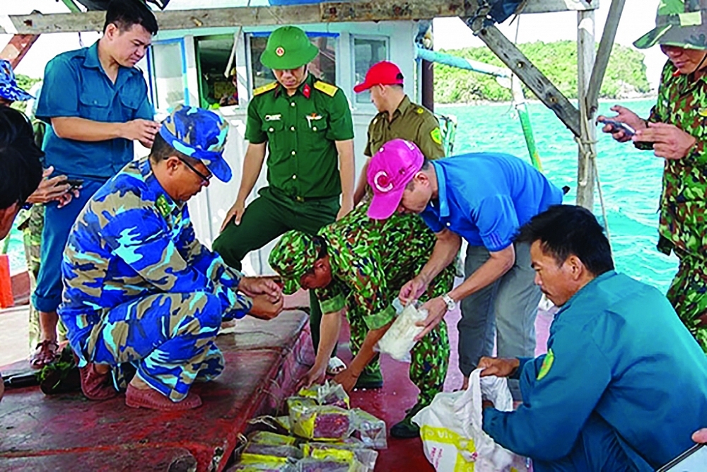 Lực lượng Biên phòng, Cảnh sát biển dùng thuyền đưa các gói nghi là ma túy trôi dạt trên biển từ Hòn Từ về xã đảo Thổ Châu để kiểm tra.	
