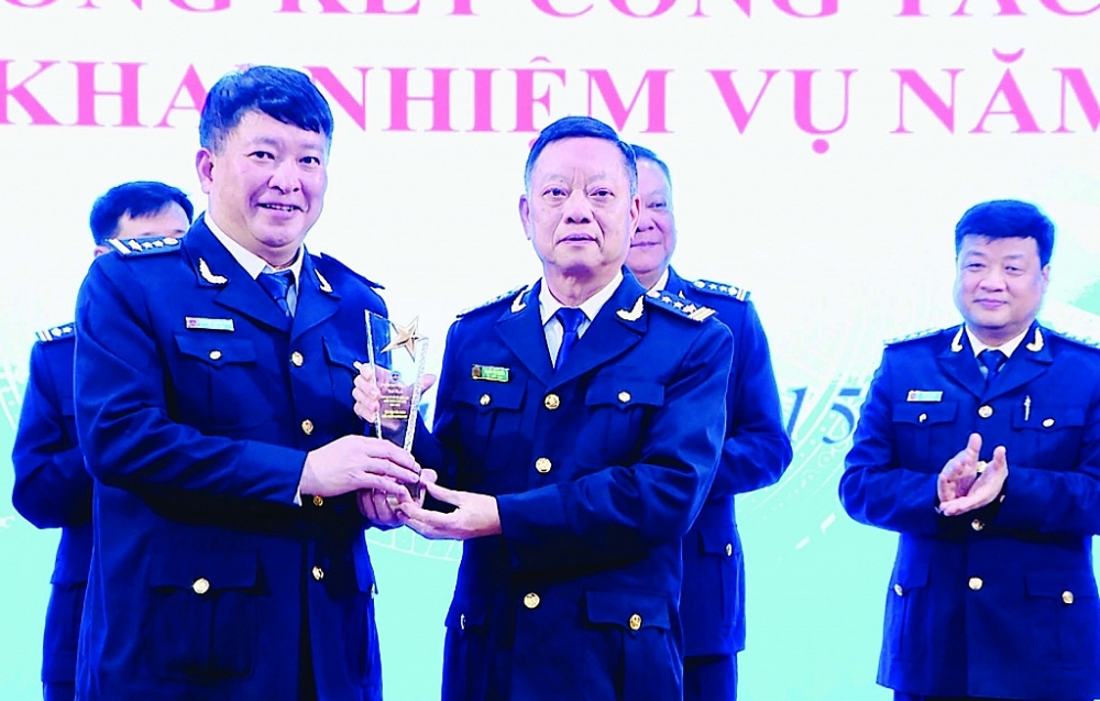 Cục trưởng Cục Hải quan Quảng Ninh Nguyễn Văn Nghiên (bên phải) trao kỷ niệm chương cho đại diện Chi cục Hải quan cửa khẩu Hoành Mô. 	Ảnh: Quang Hùng