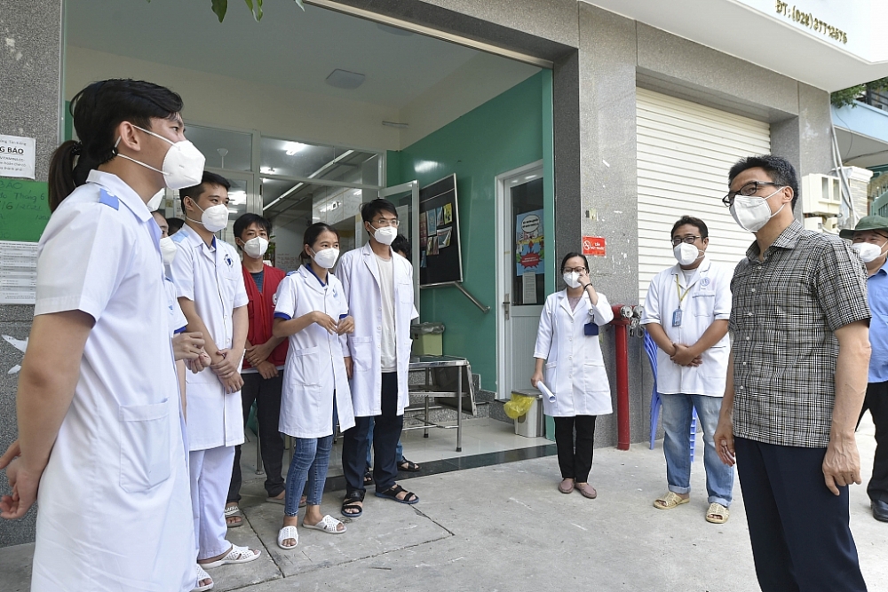 Phó Thủ tướng Vũ Đức Đam trò chuyện với các nhân viên y tế tại Trạm Y tế phường Tân Kiểng, Quận 7. Ảnh: VGP/Đình Nam