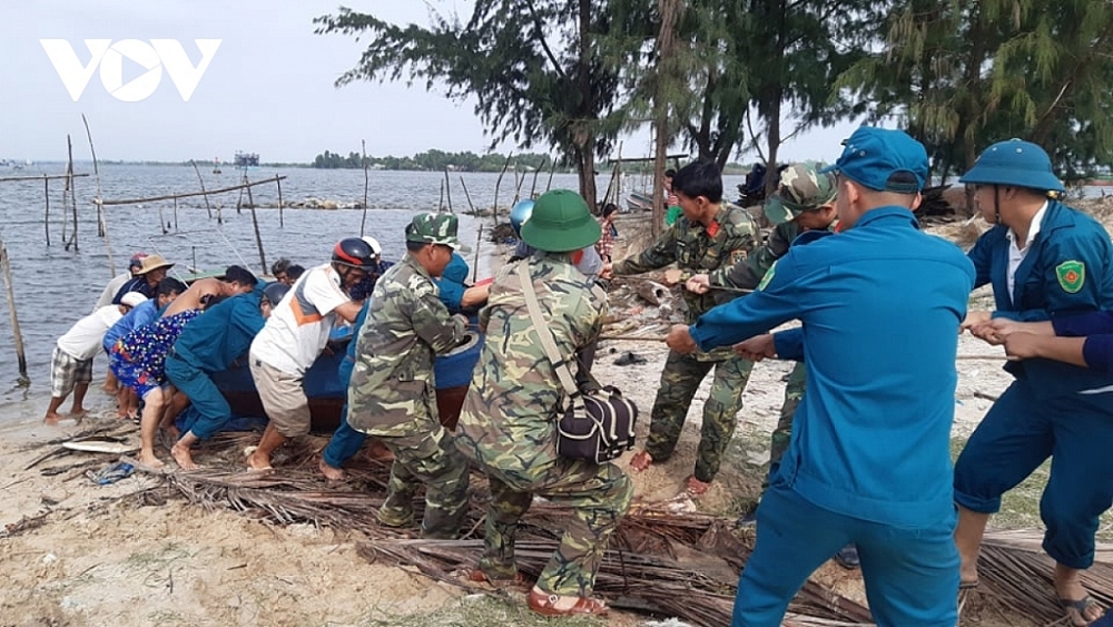 Các lực lượng chức năng ở Quảng Nam hỗ trợ người dân đưa thuyền lên bờ tránh bão. Ảnh: VOV