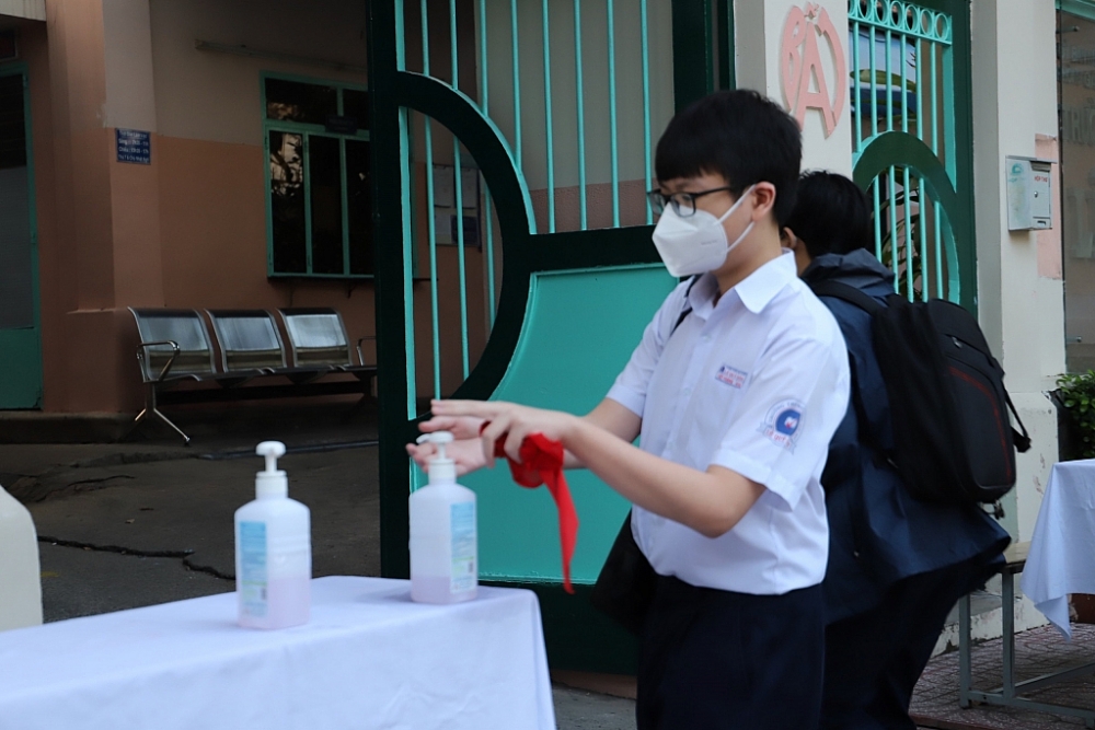 Học sinh trường THCS Lê Quý Đôn, quận 3 thực hiện rửa tay sát khuẩn trước khi vào trường. Ảnh T.D
