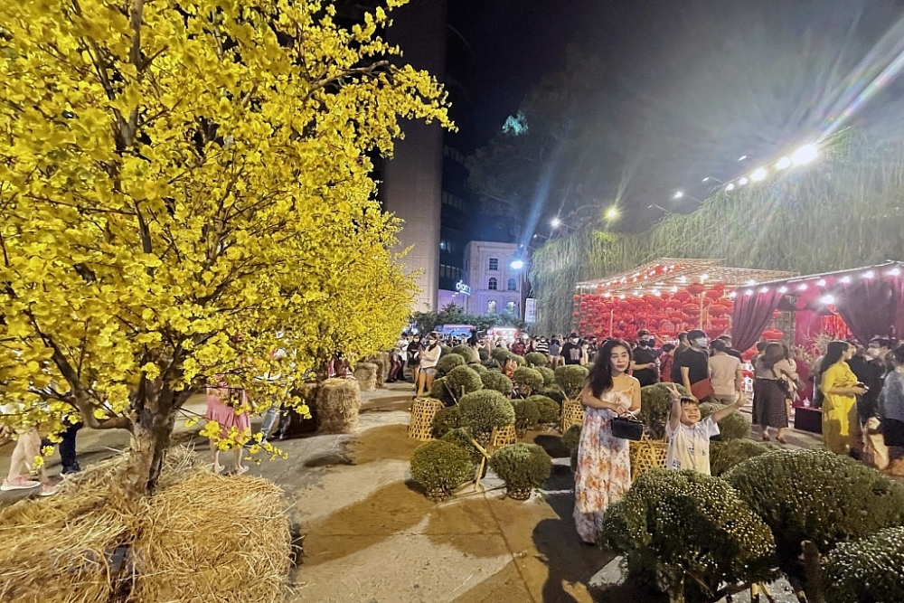 Người dân Thành phố Hồ Chí Minh chụp ảnh lưu niệm bên tiểu cảnh mùa Xuân tại Lễ hội Tết Việt lần 3 năm 2022. Ảnh minh họa: TTXVN