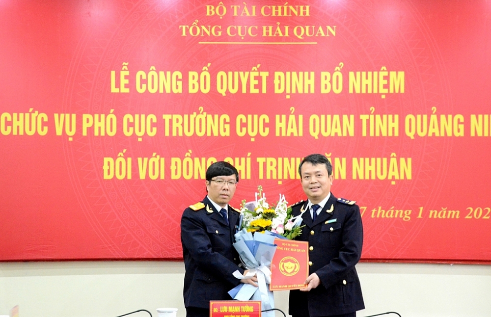 Phó Tổng cục trưởng Tổng cục Hải quan Lưu Mạnh Tưởng (bên trái) tăng hoa chúc mừng và trao quyết định bổ nhiệm cho ông Trịnh Văn Nhuận.