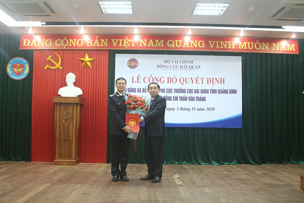 Phó Tổng cục trưởng Tổng cục Hải quan Hoàng Việt Cường tặng hoa chúc mừng và trao quyết định cho ông Trần Văn Tráng. Ảnh: Minh Hồng