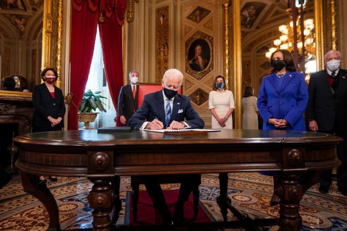 Tổng thống Joe Biden đặt bút ký 3 văn kiện đầu tiên trên cương vị người đứng đầu Nhà Trắng, bao gồm Tuyên bố trong Ngày nhậm chức, Quyết định đề cử các vị trí trong nội các, và Quyết định đề cử các vị trí phụ trong nội các. Ảnh: Reuters