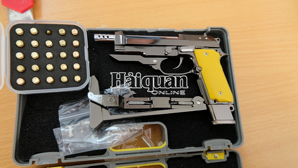 Một gói hàng chứa sản phẩm hình dạng súng và phụ kiện kèm theo.