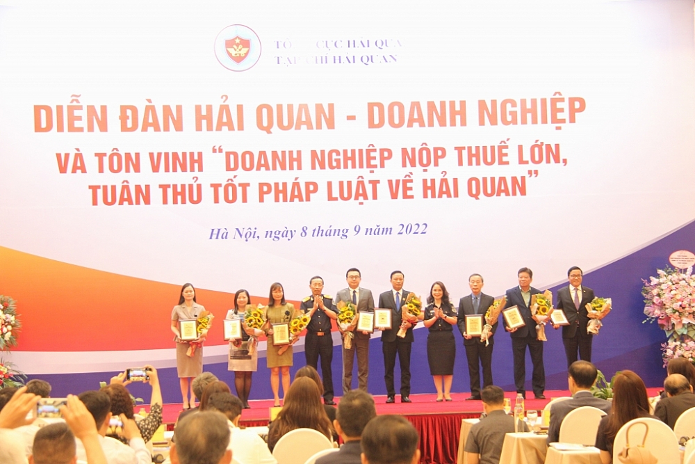 Tổng cục trưởng Tổng cục Hải quan Nguyễn Văn Cẩn và Tổng biên tập Tạp chí Hải quan đã trao Kỷ niệm chương và hoa cho đại diện 9 doanh nghiệp được tôn vinh. Ảnh: Thái Bình