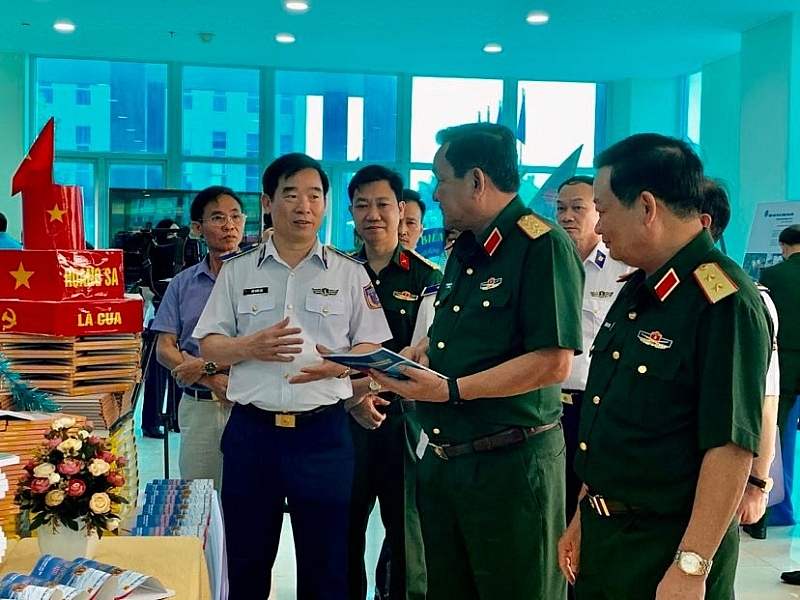Thượng tướng Võ Minh Lương và Thiếu tướng Bùi Quốc Oai cùng các đại biểu tham quan khu trưng bày hệ thống sách, tài liệu, tờ rơi...phục vụ công tác tuyên truyền thực hiện Đề án.