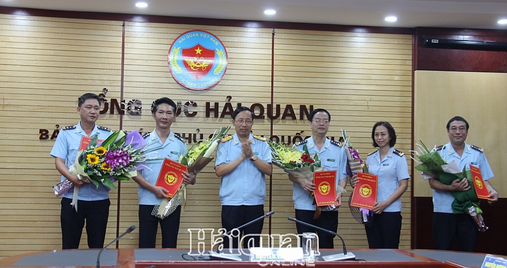 Tổng cục trưởng Nguyễn Văn Cẩn trao quyết định và tặng hoa cho các cá nhân. Ảnh: H.Nụ