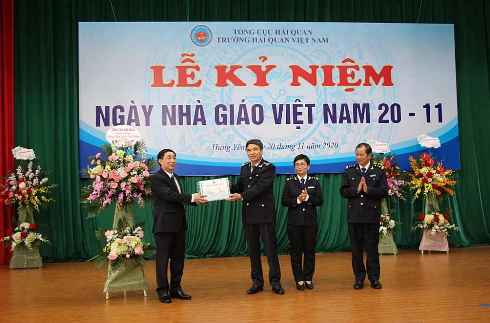 Phó Tổng cục trưởng Hoàng Việt Cường tặng hoa chúc mừng nhà trường. Ảnh: Ngô Dũng