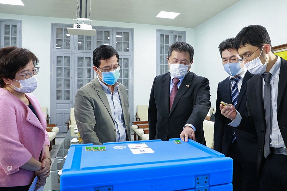 Ông SHIMIZU Akira, Trưởng Đại diện JICA Việt Nam (thứ 3 từ trái sang) và GT-TS Đặng Đức Anh, Viện trưởng NIHE (thứ 2 từ trái sang) cùng kiểm tra hòm lạnh bảo quản vắc xin.