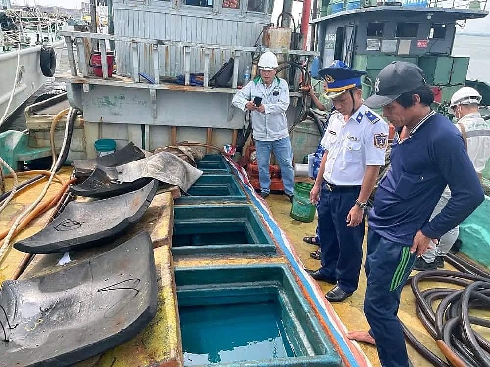 Lực lượng Cảnh sát biển kiểm tra số tang vật là dầu DO vận chuyển trái phép trên tàu. Ảnh: Đức Định