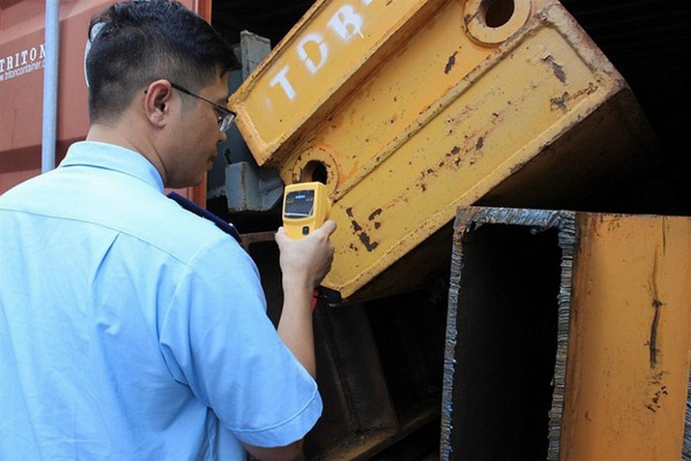  Công chức Cục Kiểm định hải quan sử dụng máy đo phóng xạ bề mặt để kiểm tra phế liệu sắt, thép NK.  Ảnh: Ngọc Linh