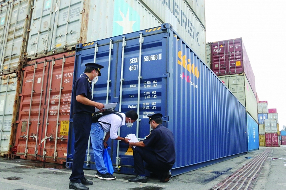 Công chức Hải quan Đồng Nai giám sát hàng hóa XNK tại cảng Đồng Nai. 	Ảnh: N.H