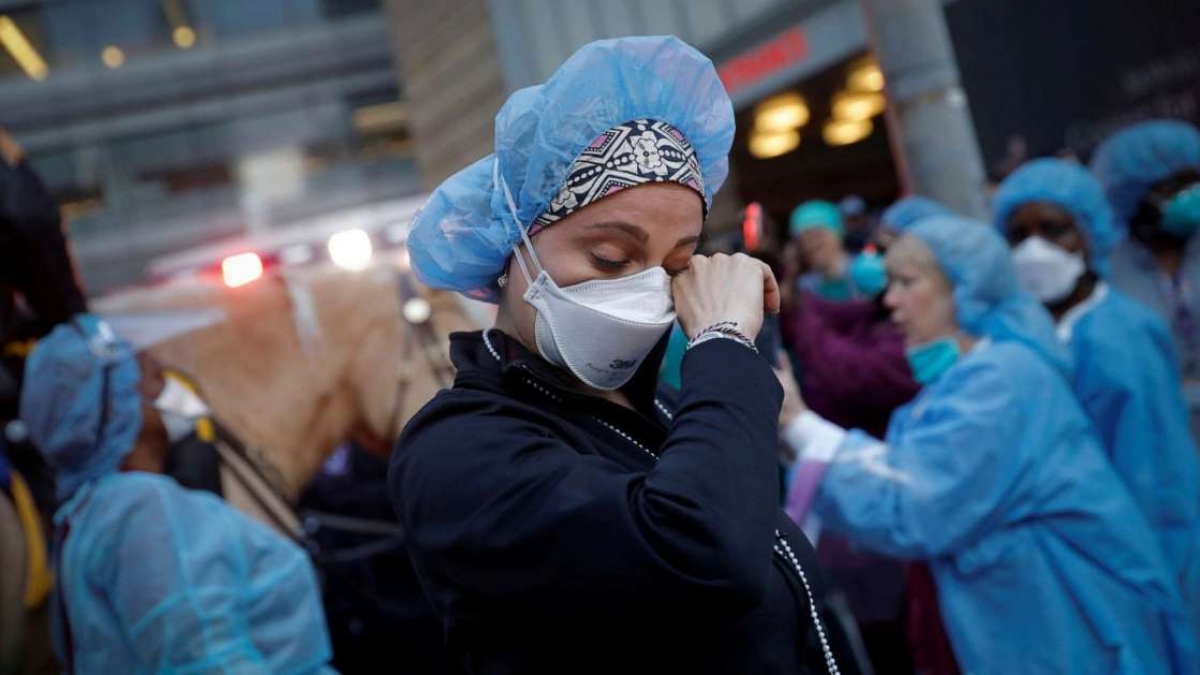 Một y tá lau nước mắt tại Trung tâm Y tế NYU Langone ở Manhattan khi cảnh sát và các đơn vị khác đến cổ vũ và cảm ơn các nhân viên y tế trong đại dịch Covid-19. Ảnh: Reuters 